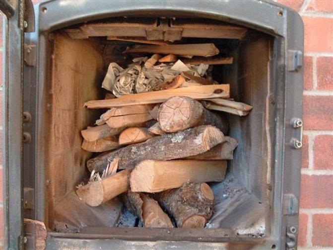 Полагане на дърва за огрев в огнището